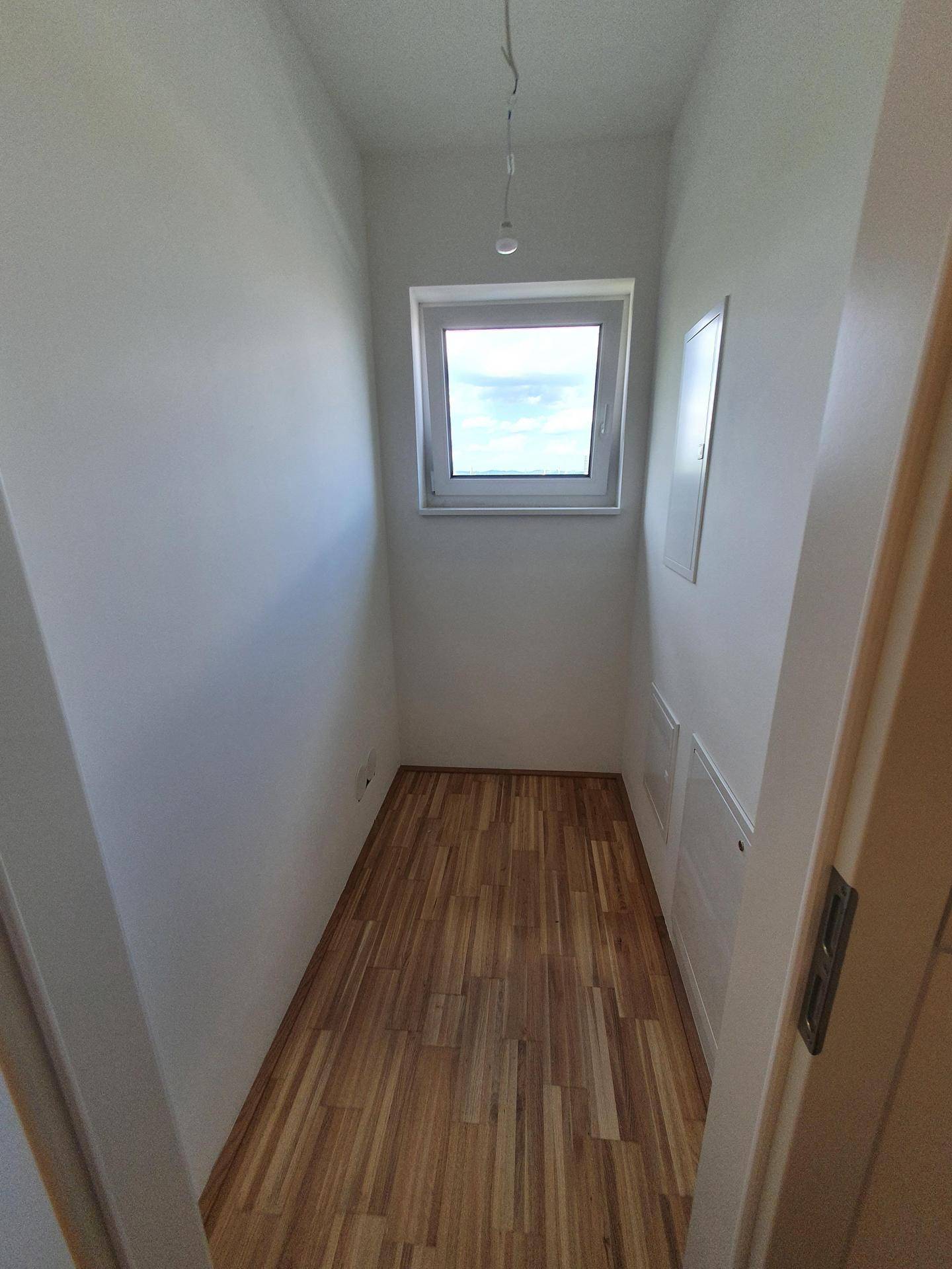 Praktischer Abstellraum mit Fenster und Parkettboden, bietet zusätzlichen Stauraum in der Wohnung.