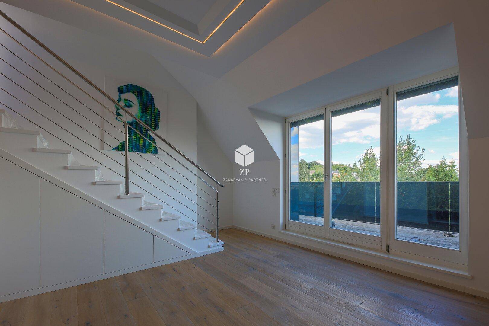 Wohnbereich mit moderner Treppe und Zugang zu einem Balkon durch große Glastüren.