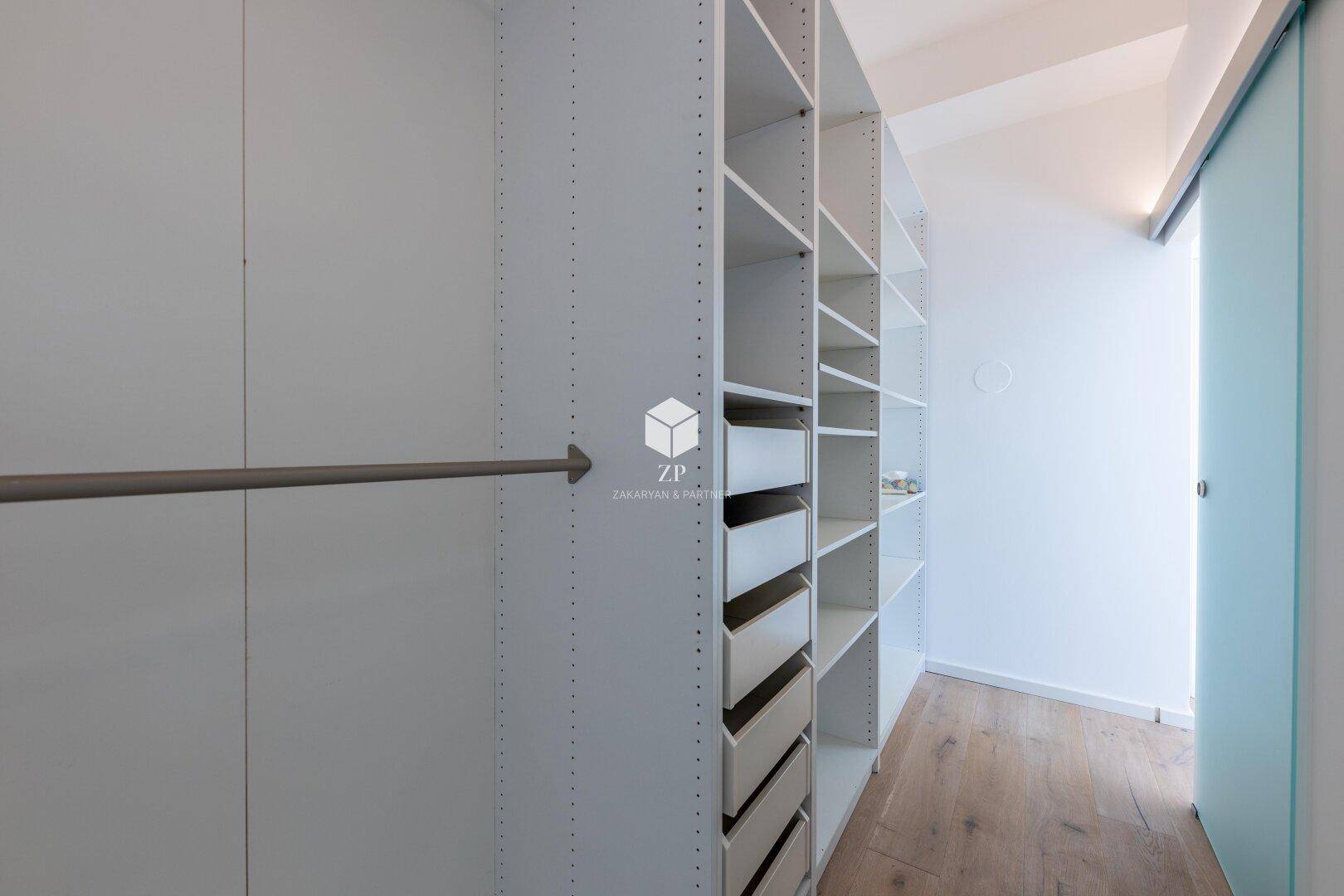 Geräumiger begehbarer Kleiderschrank mit vielen Regalen und Aufhängemöglichkeiten.