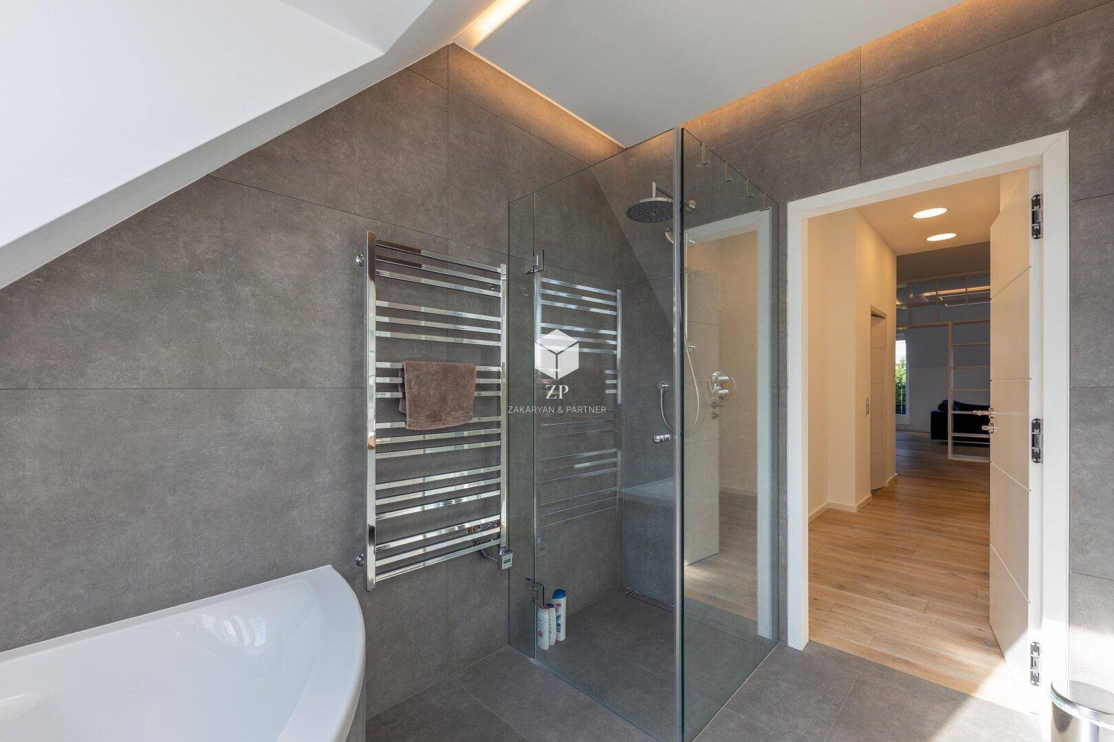Modernes Badezimmer mit begehbarer Dusche, Badewanne und beheiztem Handtuchhalter.