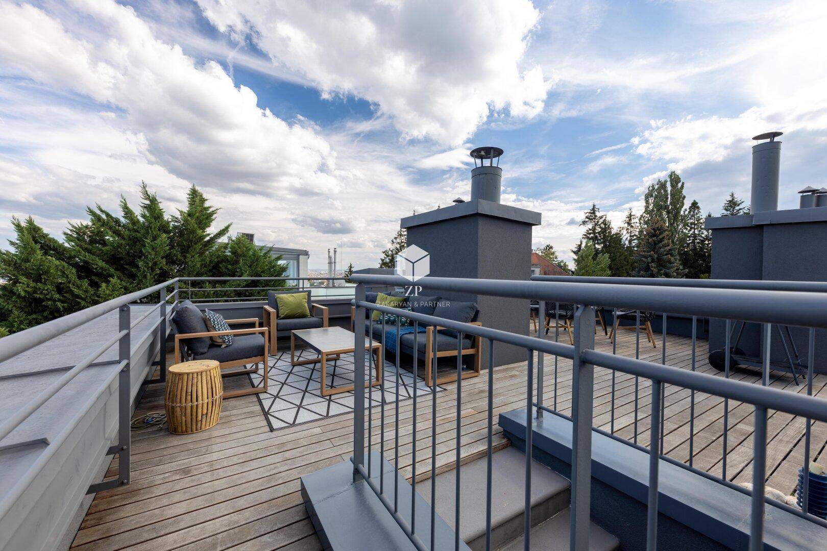 Weitläufige Dachterrasse mit Holzboden und Metallgeländer, bietet einen weiten Ausblick.