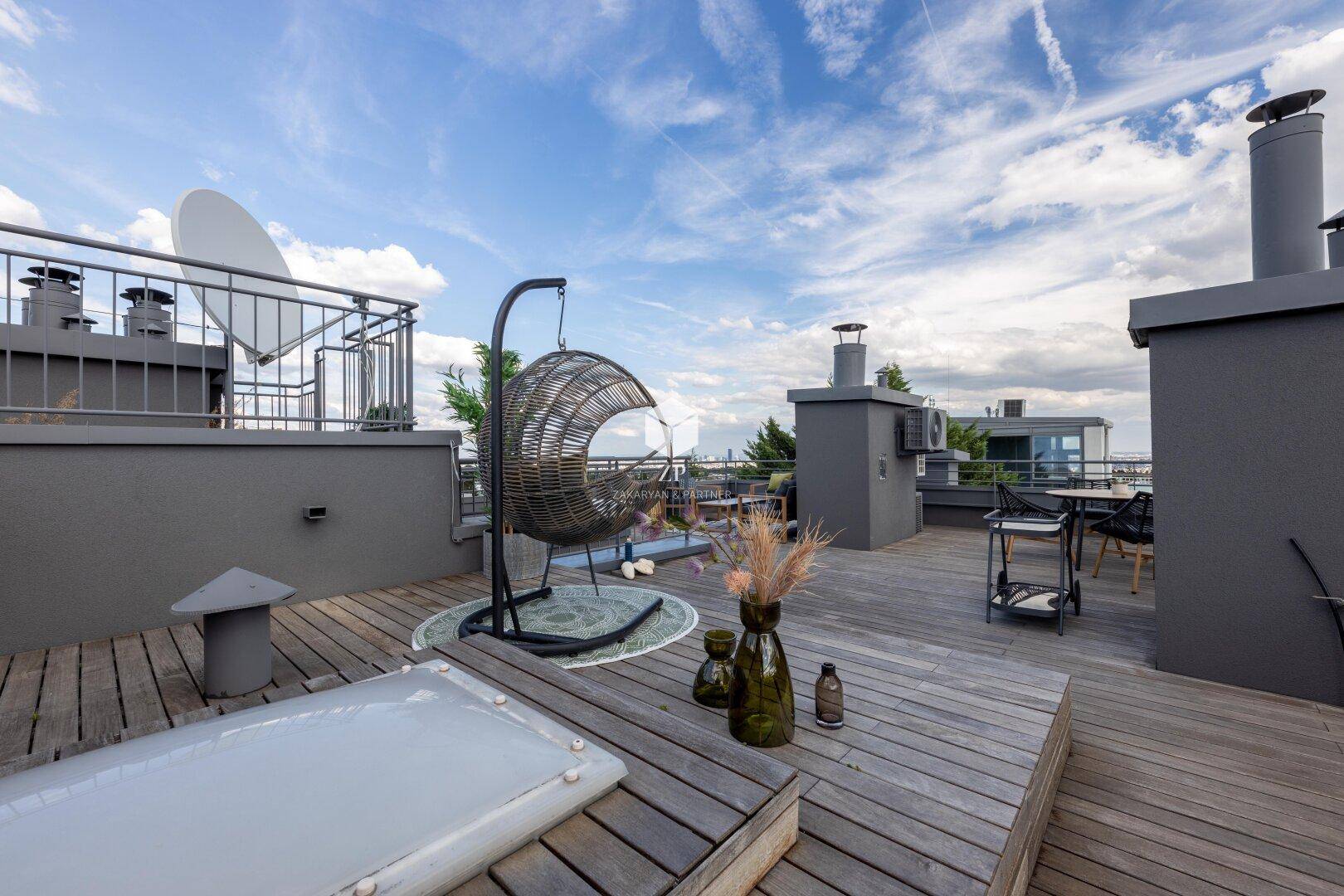 Entspannungsbereich auf der Dachterrasse mit Hängesessel und Blick auf die Umgebung.