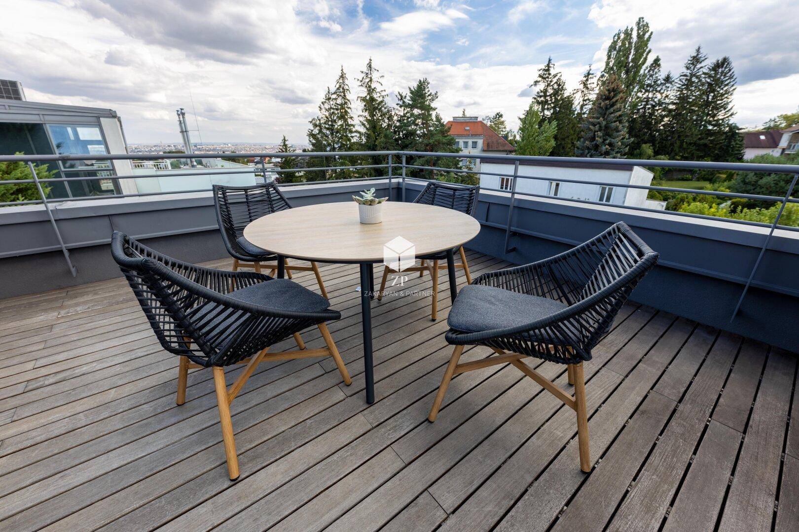 Essbereich auf der Dachterrasse mit modernem Tisch und Stühlen, umgeben von Grün.