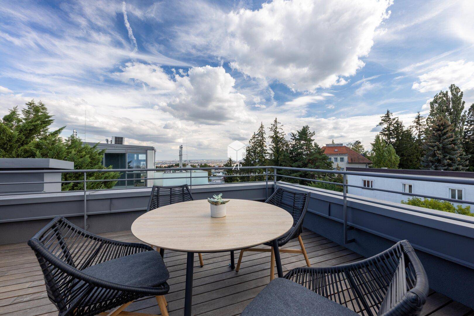 Gemütlicher Essbereich auf der Dachterrasse mit Holzboden und weitem Blick.