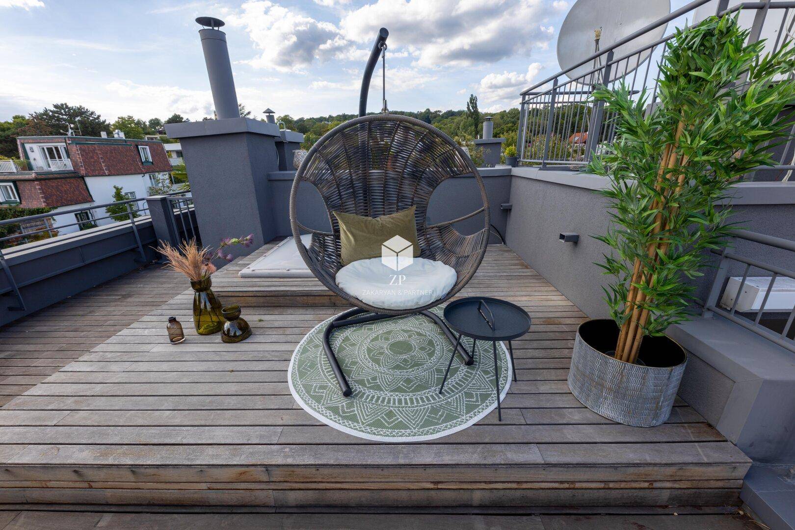 Entspannungsbereich auf der Dachterrasse mit Hängesessel und dekorativer Pflanze.