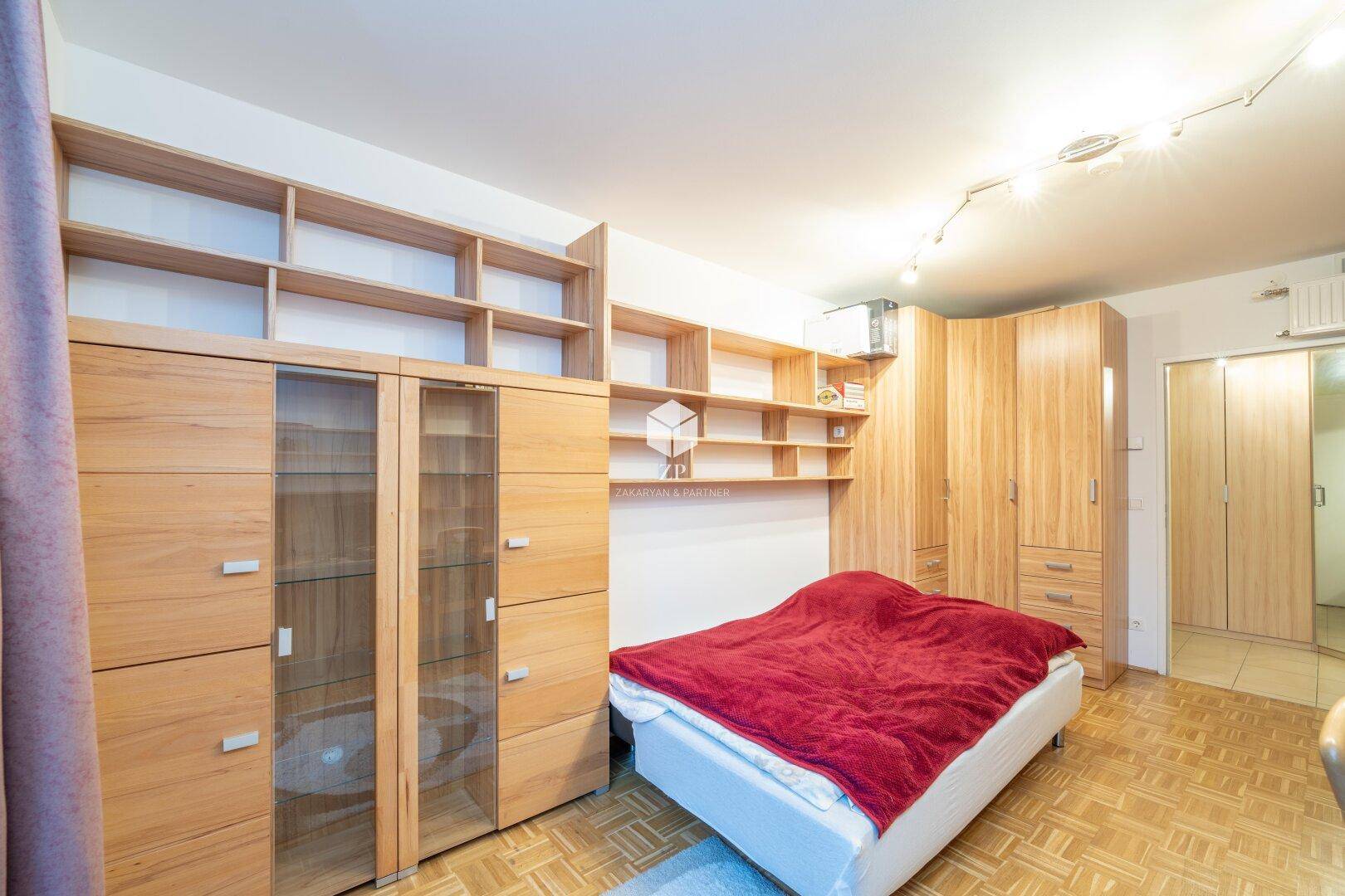 Gemütliches Schlafzimmer mit viel Stauraum durch Holzregale und Schränke.