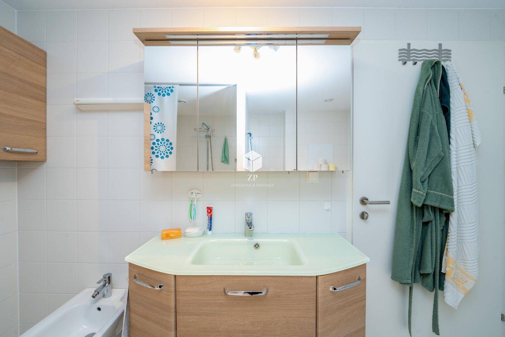 Waschtisch mit Spiegelschrank und integrierter Beleuchtung im Badezimmer.