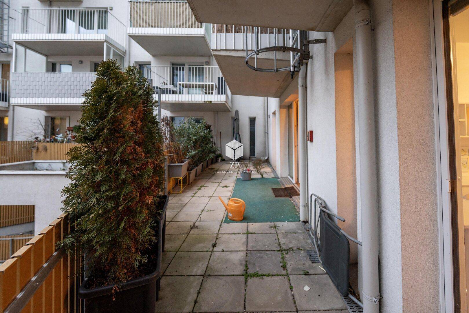 Außenbereich mit gepflasterter Terrasse, Pflanzen und Blick auf die Umgebung.
