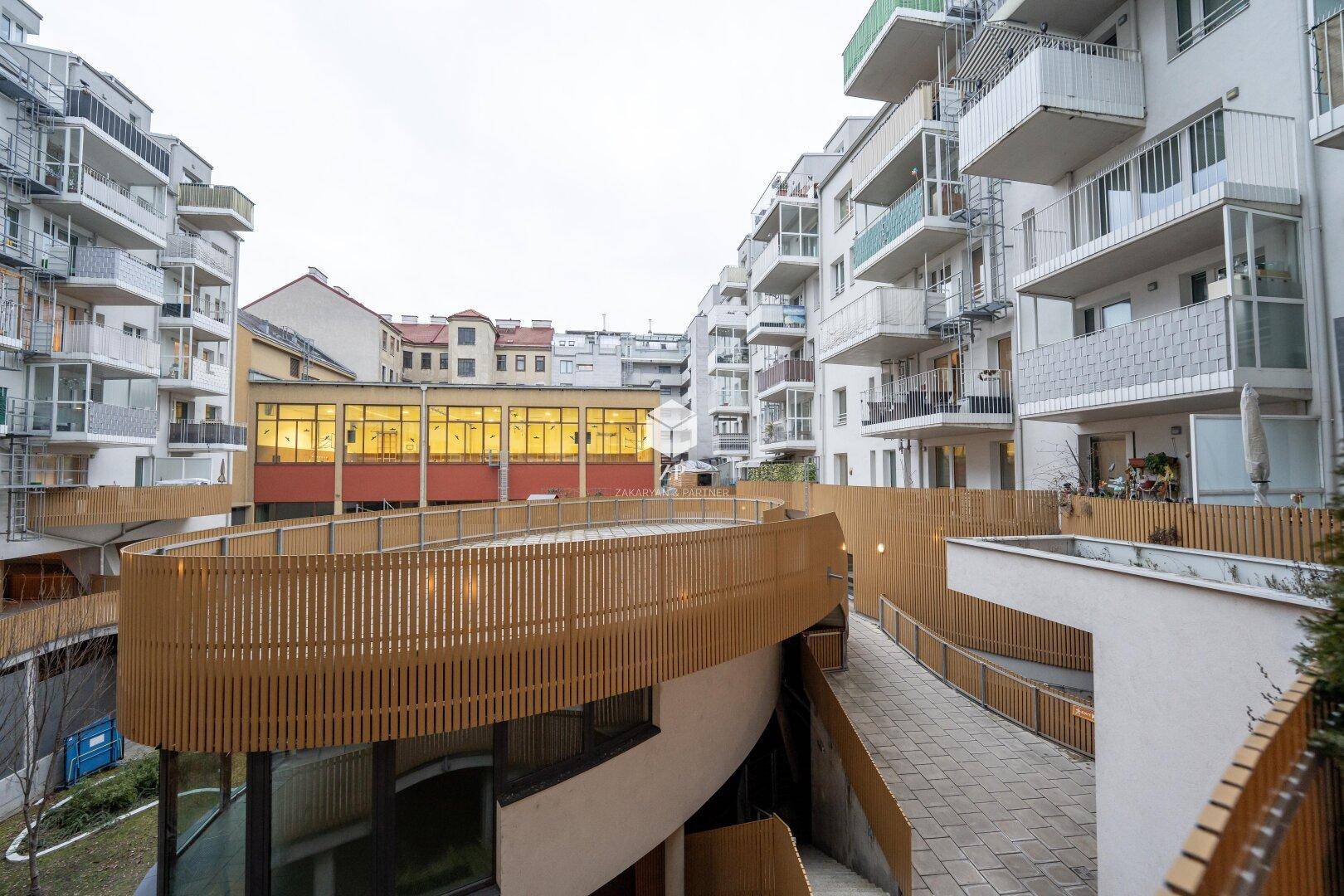 Moderner Wohnkomplex mit mehreren Balkonen und Holzverkleidungen.