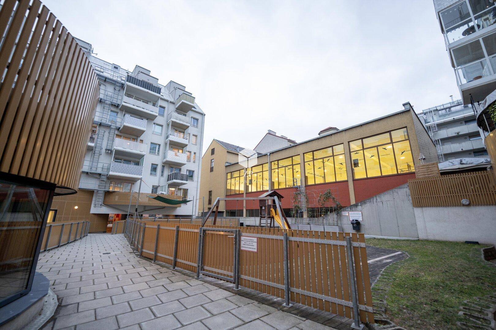 Innenhof des Wohnkomplexes mit Spielplatz und Grünflächen.