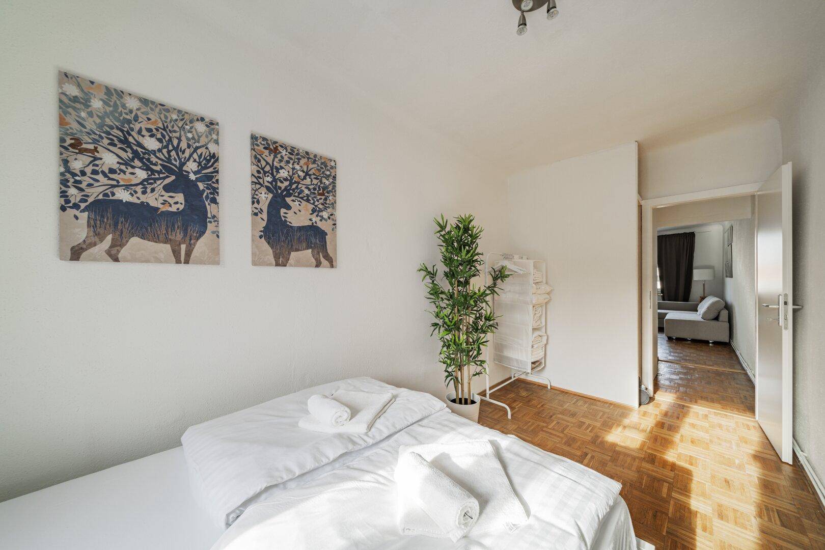 Schlafzimmer mit Parkettboden und Zugang zum Flur, hell und funktional eingerichtet.