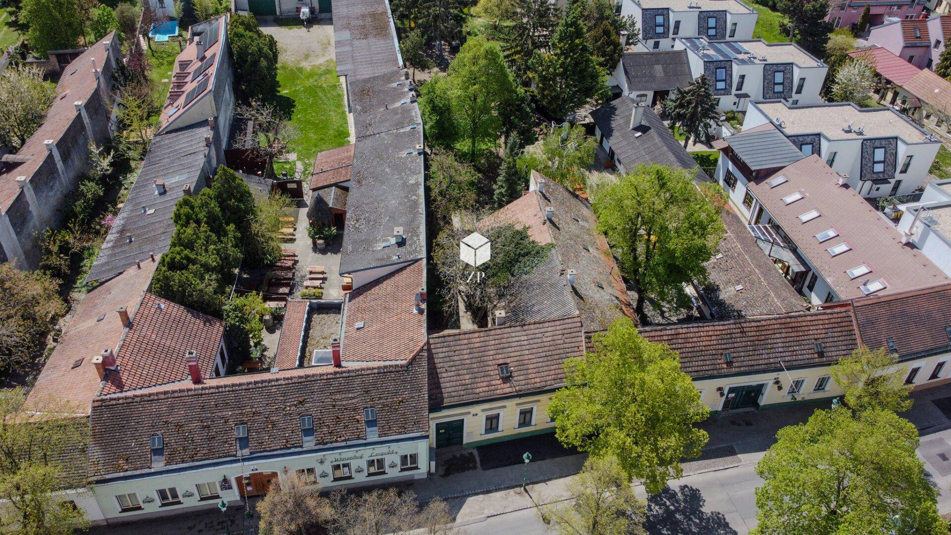 Übersichtliche Luftaufnahme des Anwesens mit umliegenden Gebäuden und viel Grünfläche.