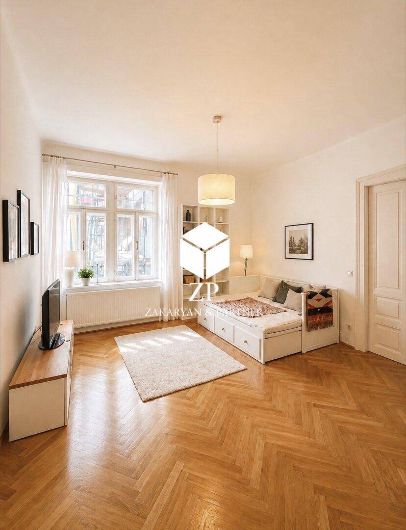 Gemütliches Schlafzimmer mit Fischgrätparkett, Tagesbett und Blick auf den Außenbereich.