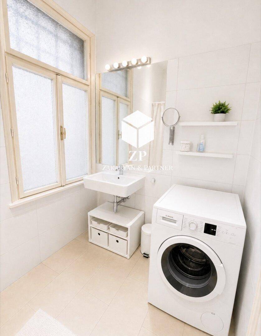 Modernes Badezimmer mit Waschmaschine, Waschbecken und großem Fenster für Tageslicht.