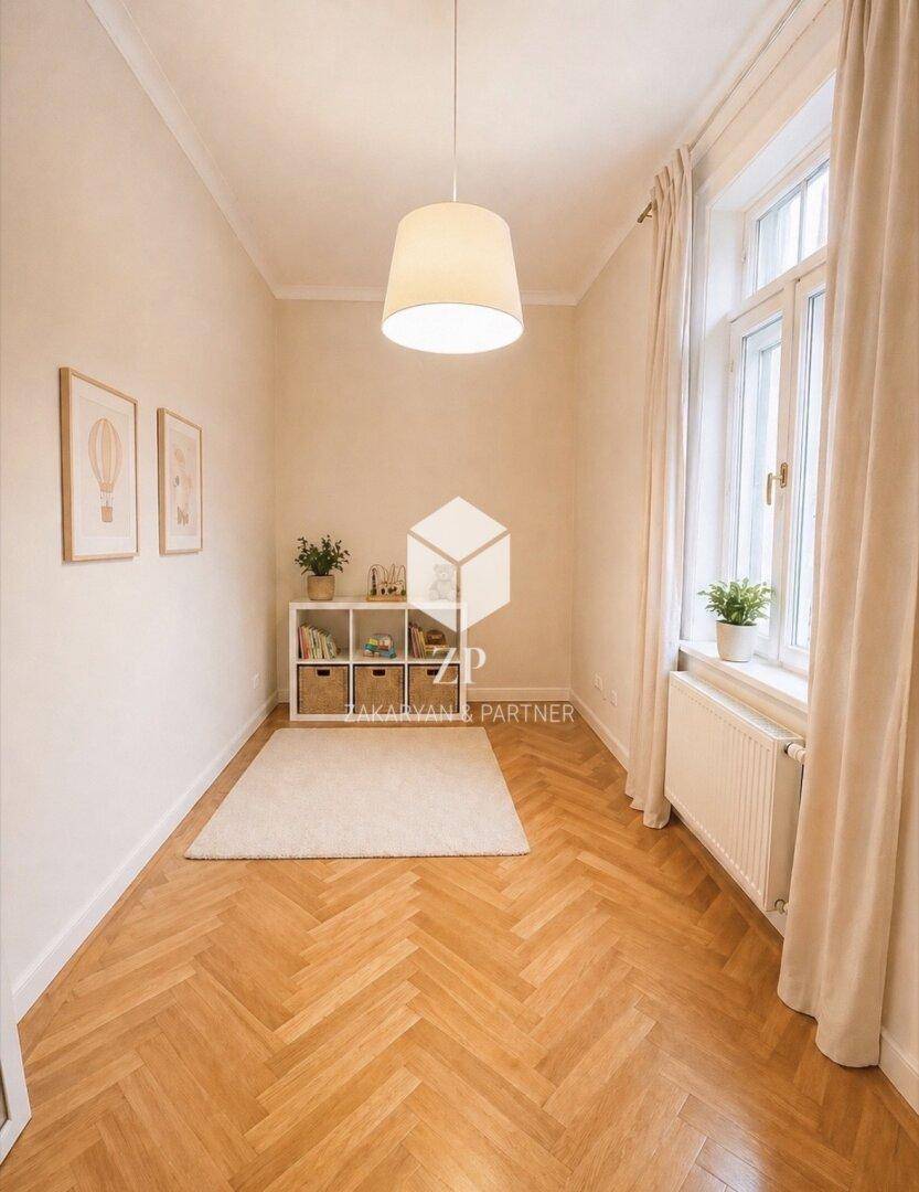 Kleiner Raum mit Fischgrätparkett, Regal und großem Fenster, ideal als Arbeitszimmer.