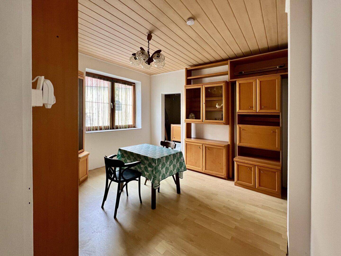 Esszimmer mit Holzboden, Holzdecke und traditionellen Möbeln, inklusive Esstisch.