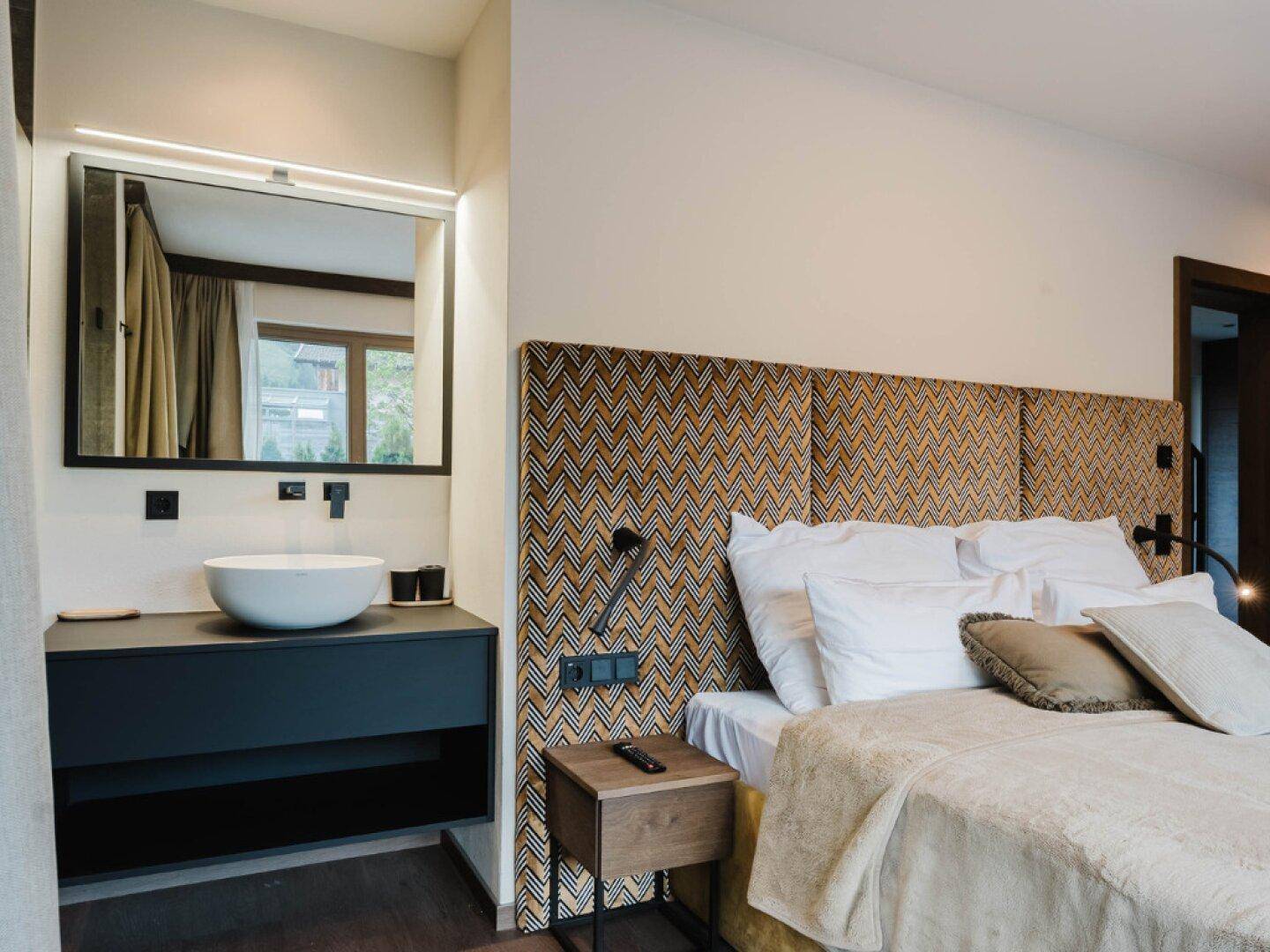 Schlafzimmer mit integriertem Waschbecken und Spiegel, kombiniert Komfort und Funktionalität.