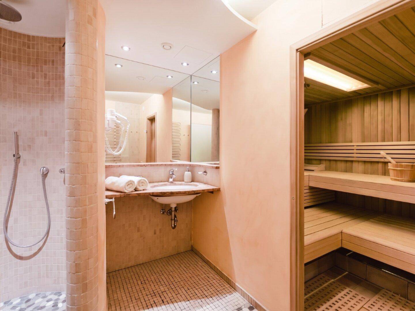 Modernes Badezimmer mit Dusche, Einzelwaschbecken und integrierter Sauna.