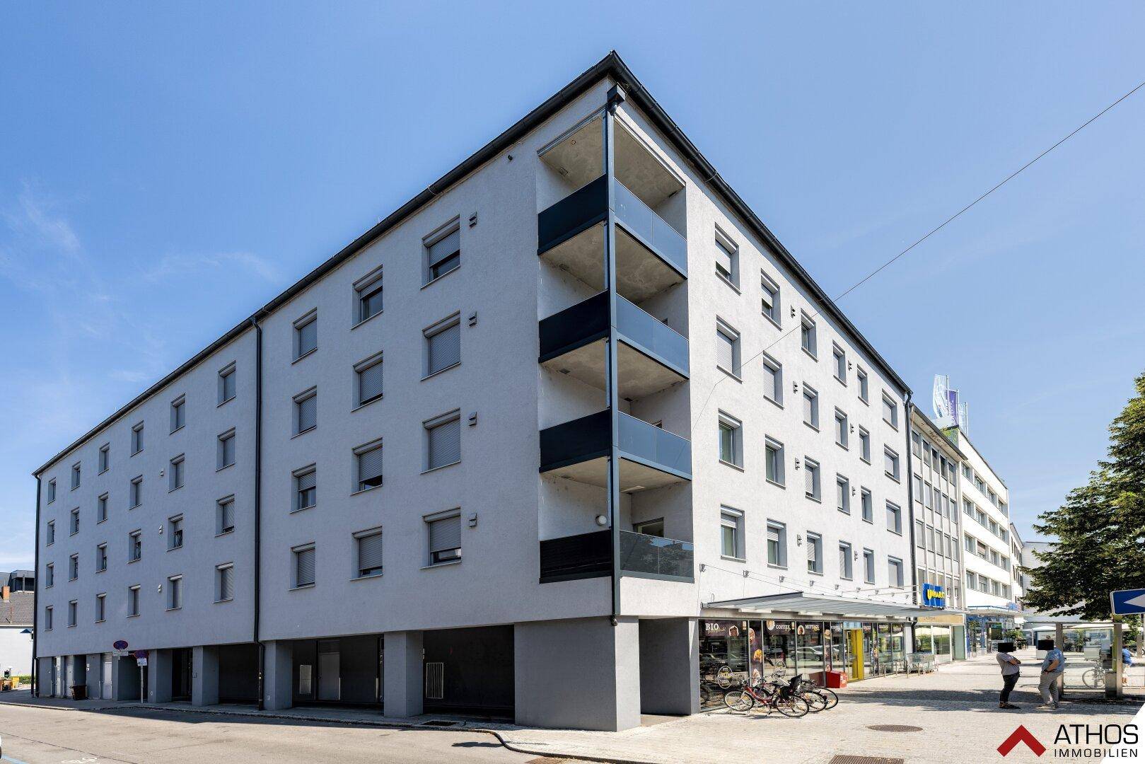 Modernes Mehrfamilienhaus mit klarer Architektur und Balkonen in städtischer Umgebung.