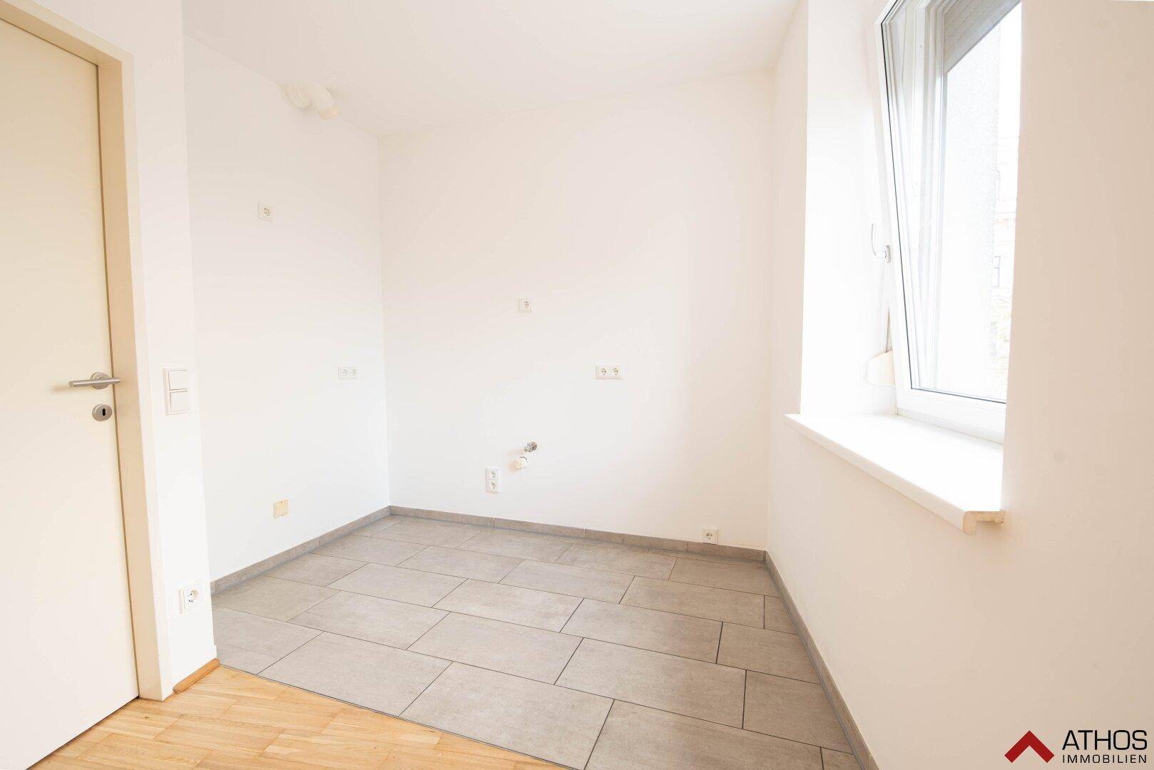 Funktionaler Raum mit Fliesenboden und Fenster, vorbereitet für Küchen- oder Hauswirtschaftsgeräte.