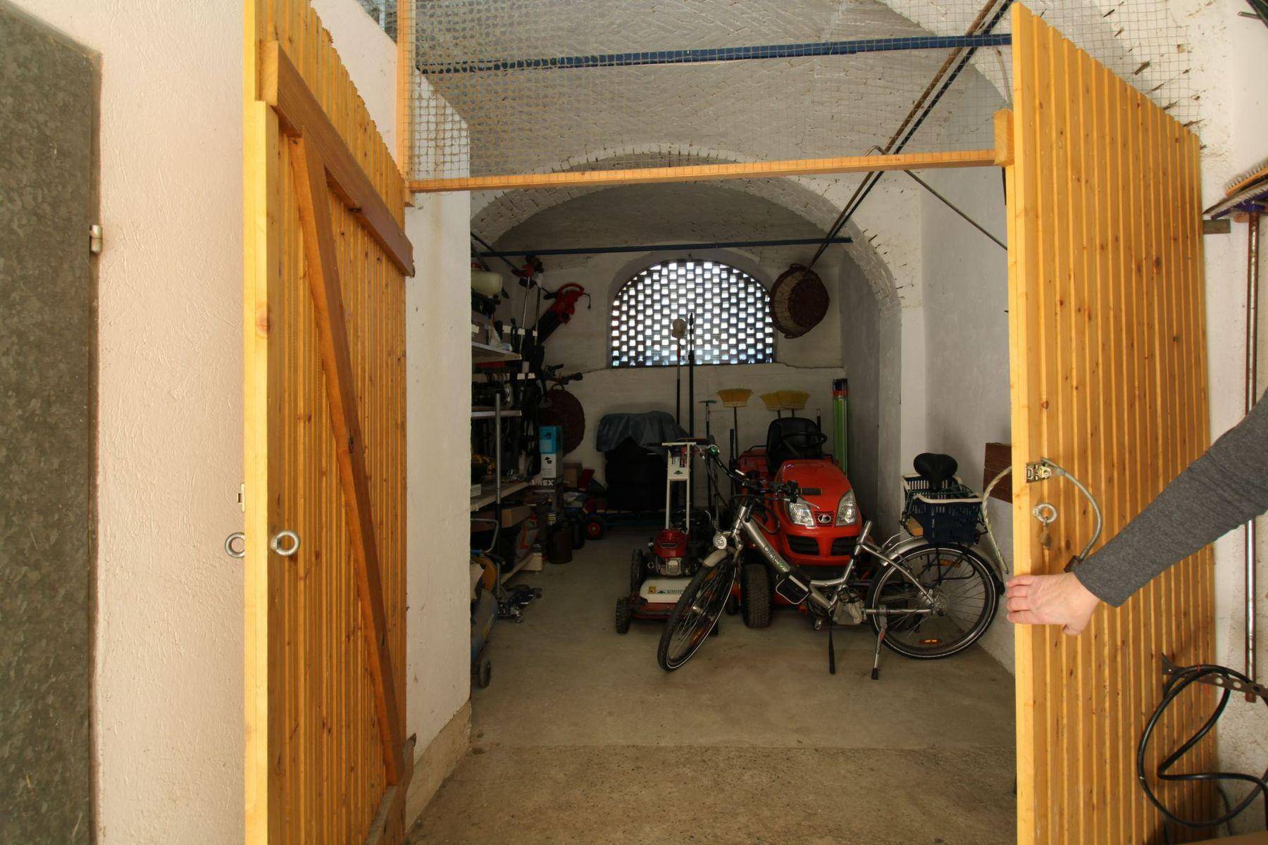 Geräumiger Abstellraum mit Werkzeugen, Fahrrädern und einer charakteristischen gewölbten Decke.