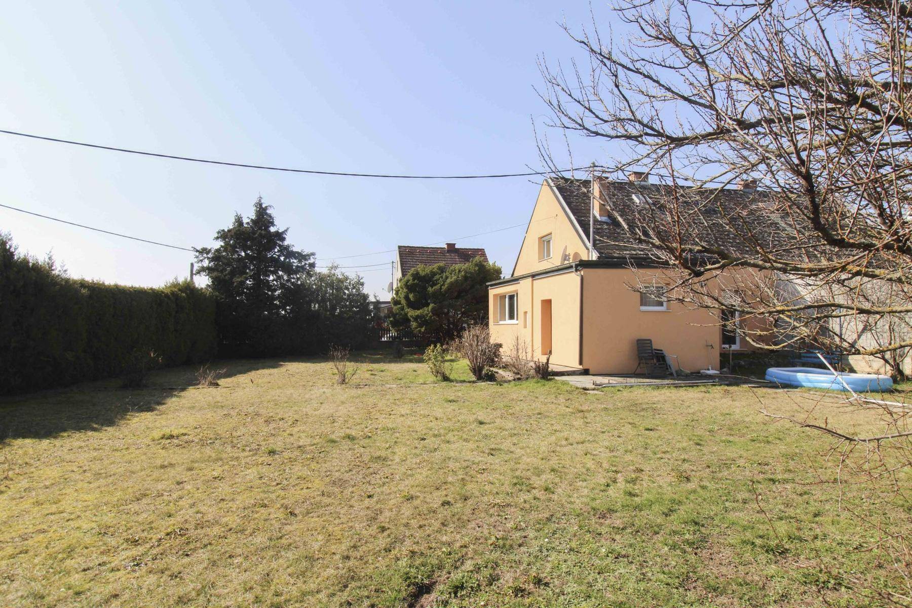Weitläufiger Garten mit Rasenfläche und Blick auf die Seitenfassade des Einfamilienhauses.