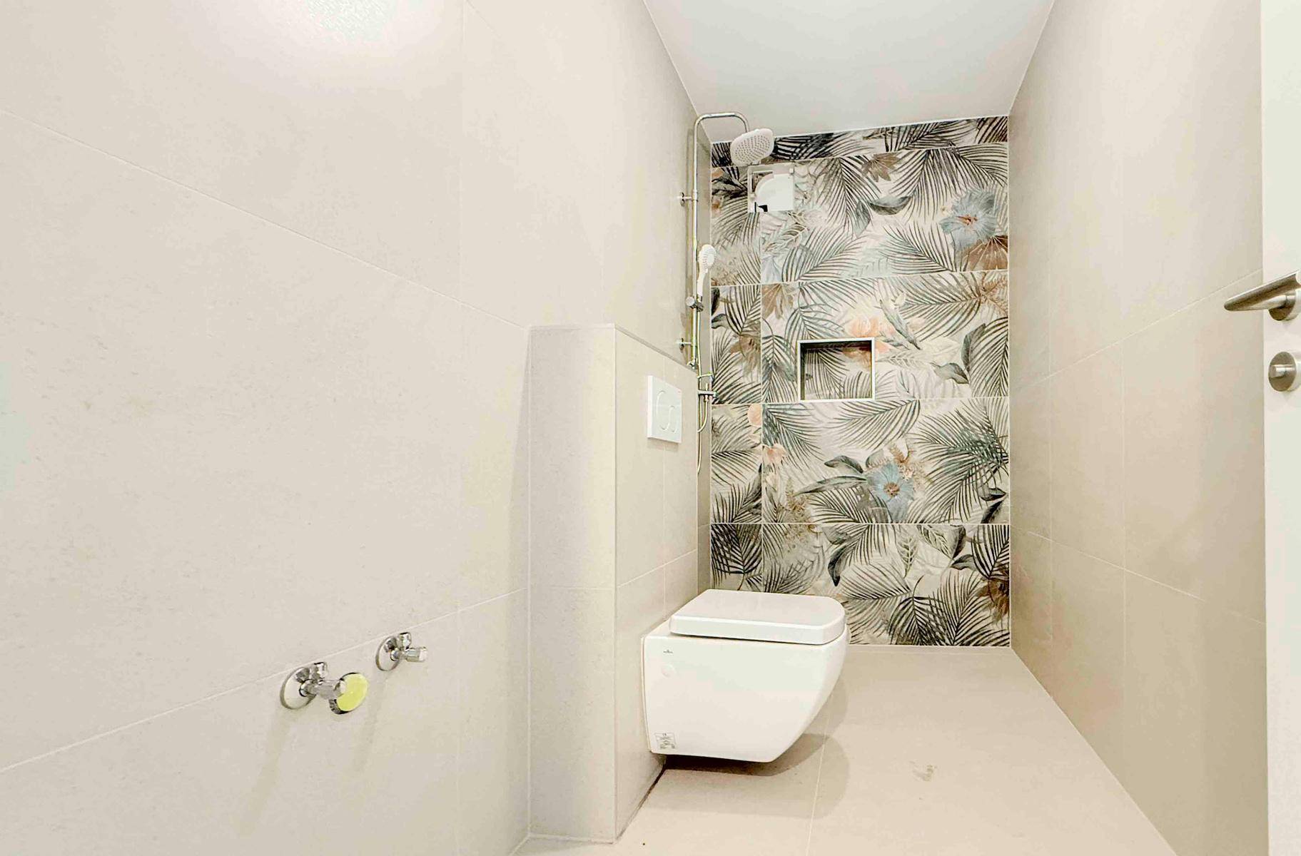 Modernes Badezimmer mit wandhängendem WC und begehbarer Dusche, verziert mit floralen Fliesen.