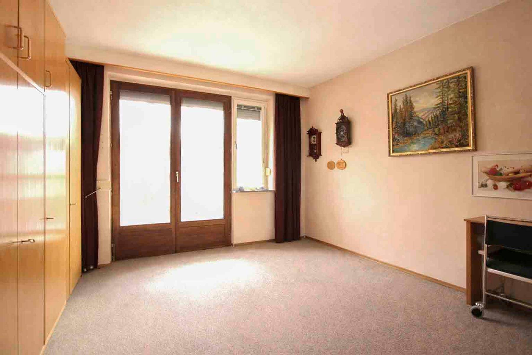 Schlafzimmer mit Teppichboden, Einbauschränken und Zugang zu einem Balkon oder Terrasse.