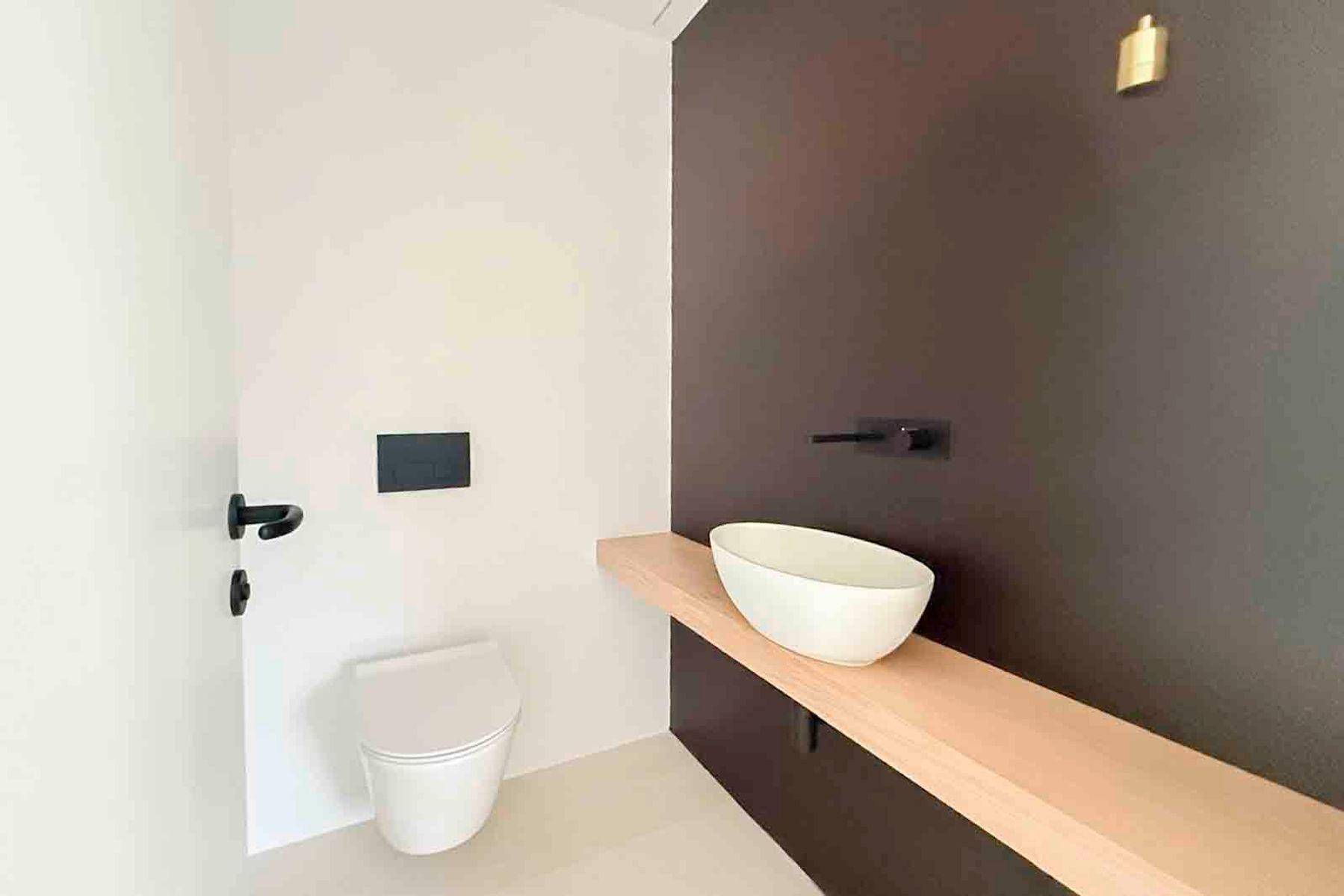 Modernes Gäste-WC mit wandhängender Toilette und stilvollem Aufsatzwaschbecken.