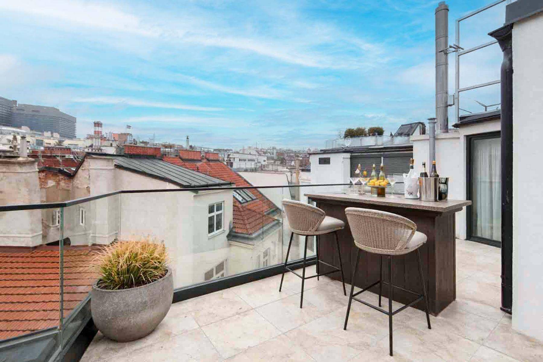 Dachterrasse mit Bar und Hockern, ideal für Unterhaltung mit Stadtblick.