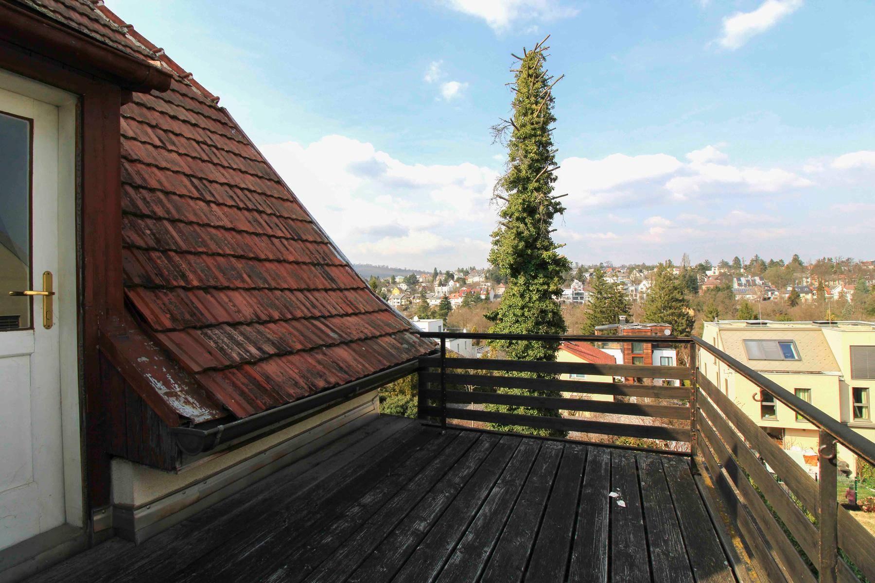 Holzbalkon mit Blick auf die umliegende Landschaft und den Himmel.