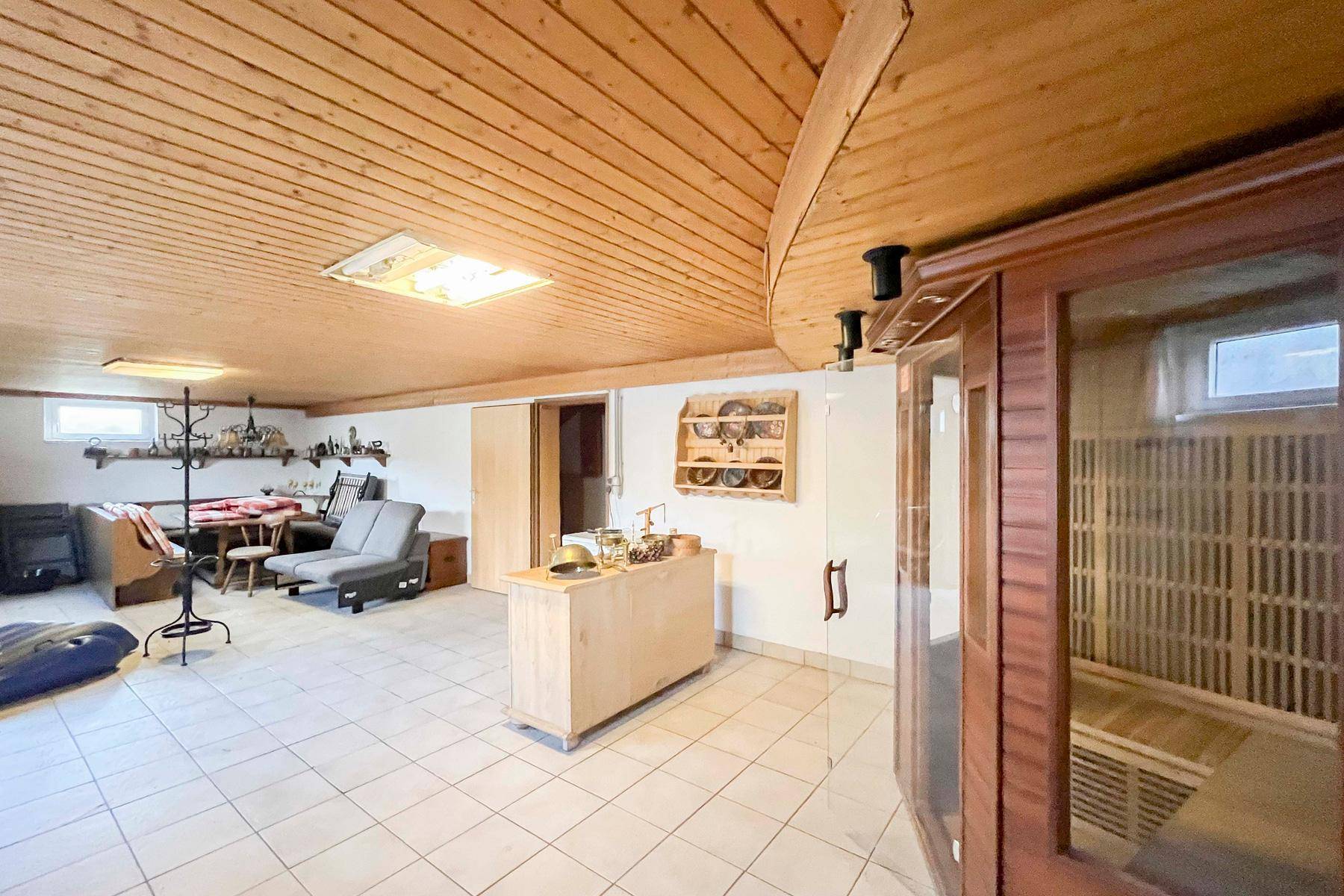 Ausgebauter Kellerraum mit Sauna, Fliesenboden und Holzdecke, ideal für Wellness.