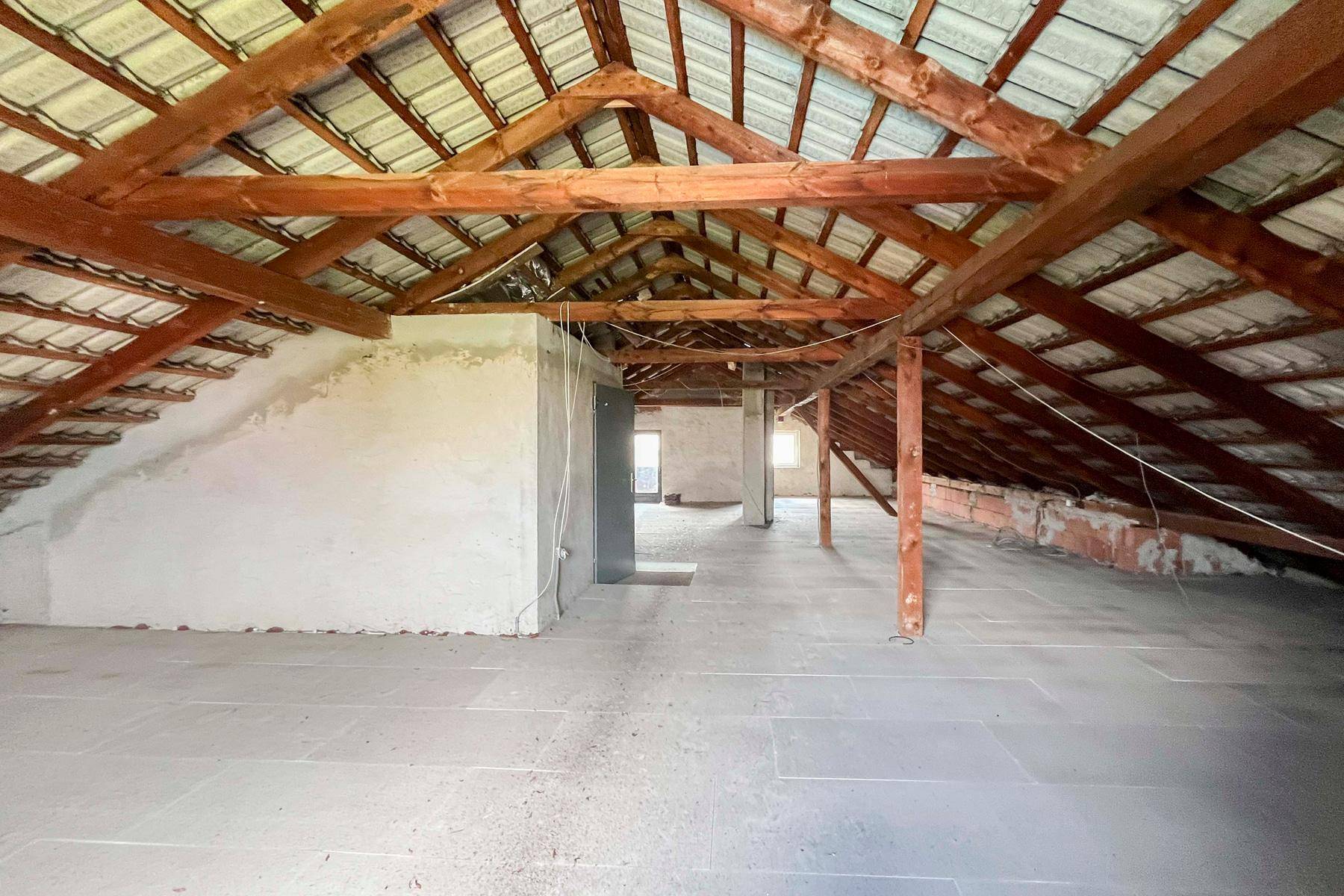 Unausgebauter Dachboden mit sichtbaren Holzbalken und Dachschrägen, bietet Ausbaupotenzial.
