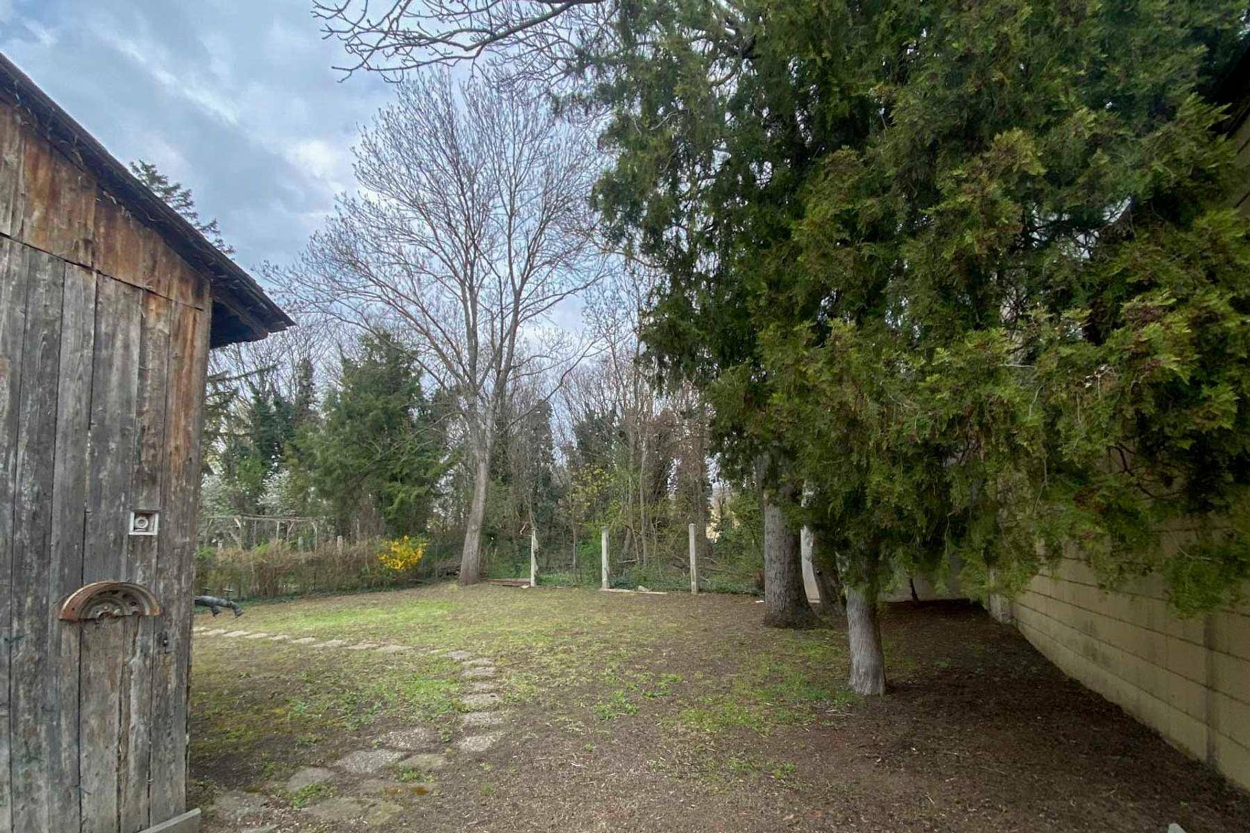 Großer Gartenbereich mit altem Baumbestand und einer weitläufigen Rasenfläche.