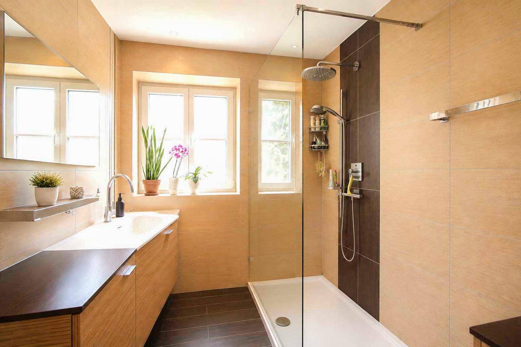 Modernes Badezimmer mit begehbarer Dusche, Doppelwaschbecken und Fenster.