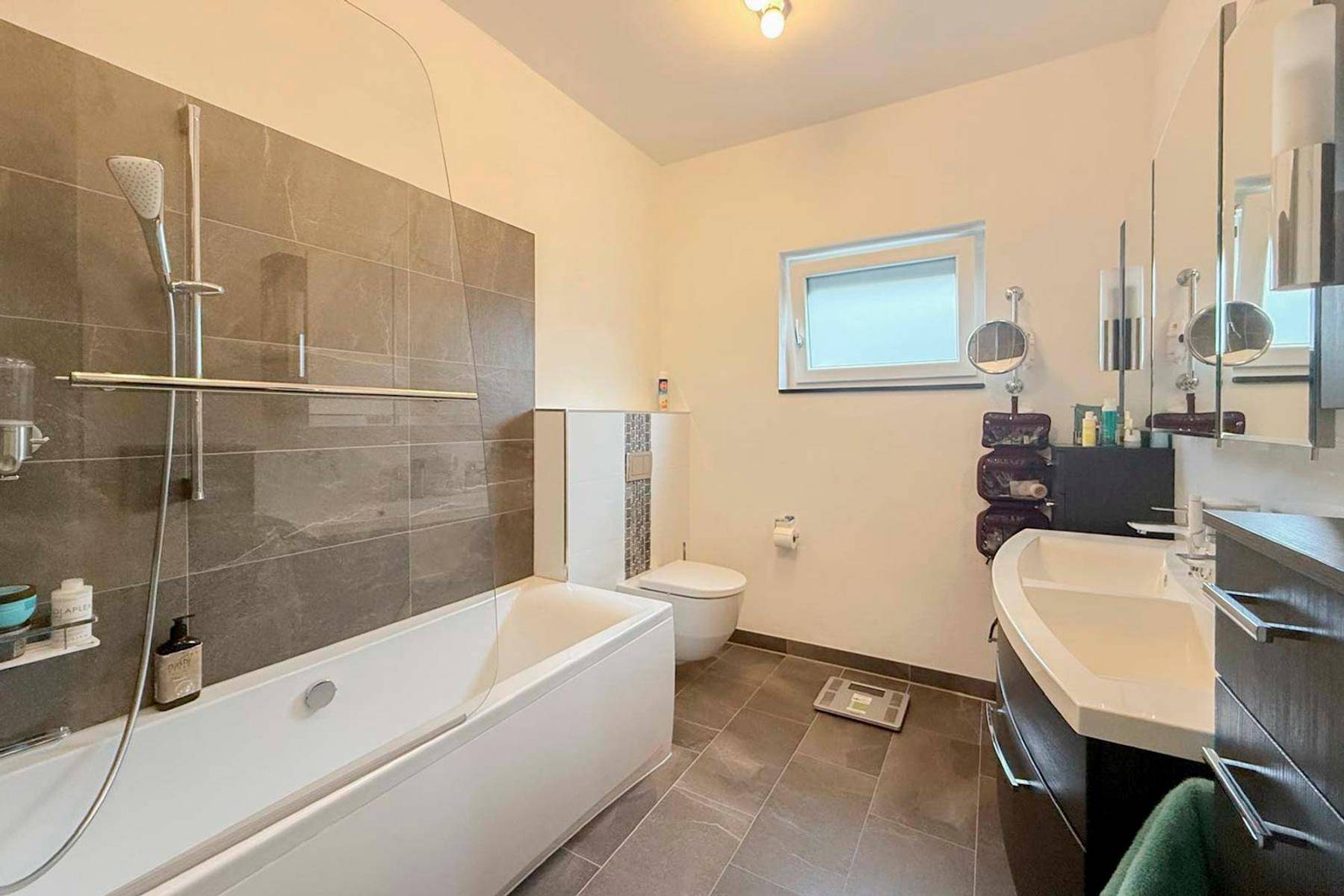 Geräumiges Badezimmer mit Badewanne, Toilette und Doppelwaschbecken.