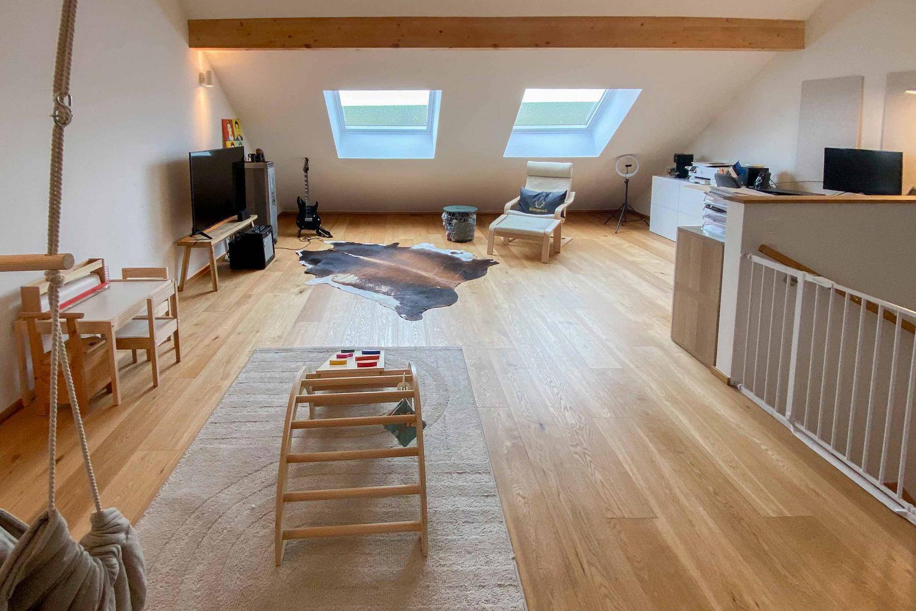 Geräumiger Dachbodenraum mit Holzbalken, Dachfenstern und vielseitiger Nutzung.