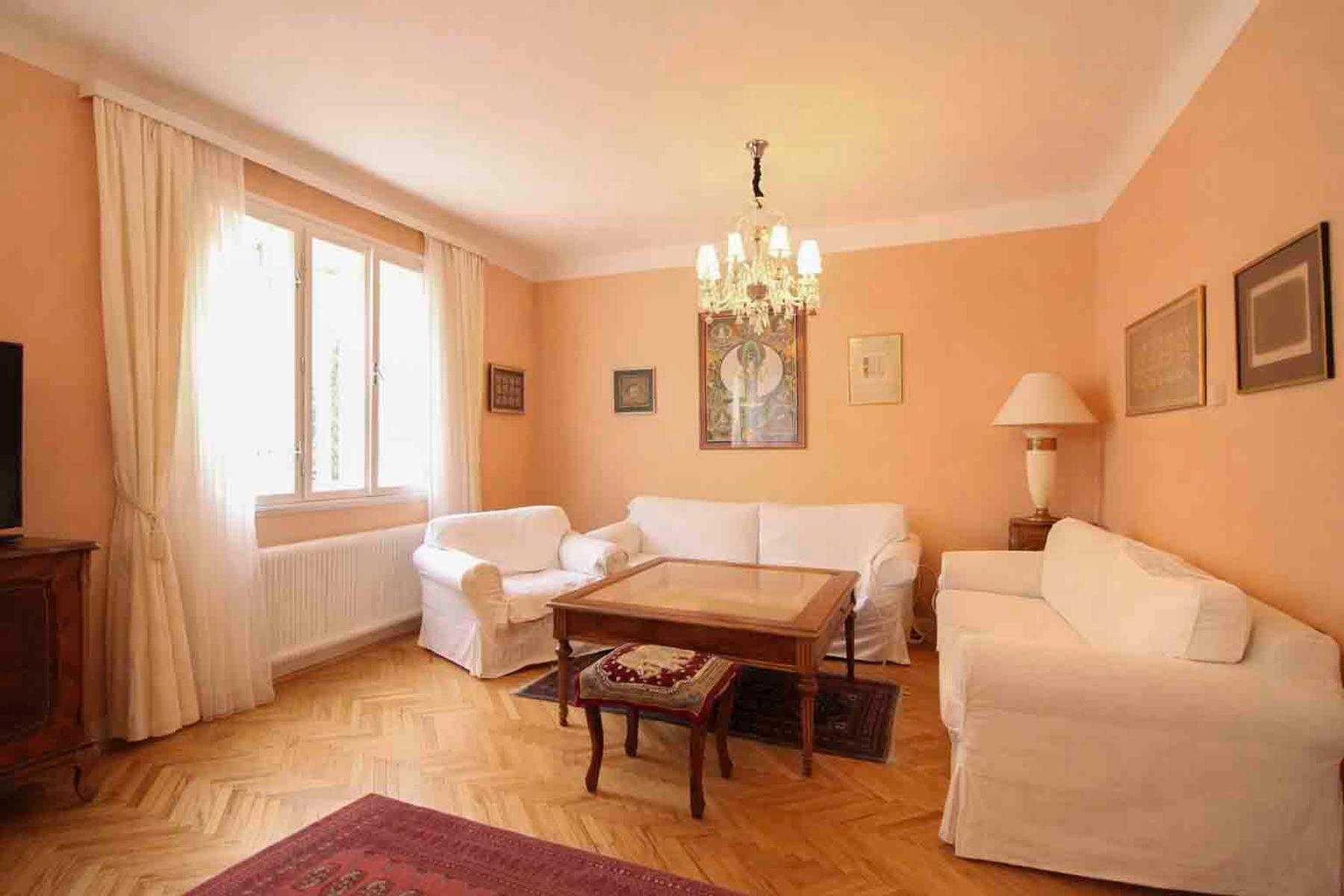 Gemütlicher Wohnbereich mit hellen Sofas, einem eleganten Kronleuchter und Parkettboden.