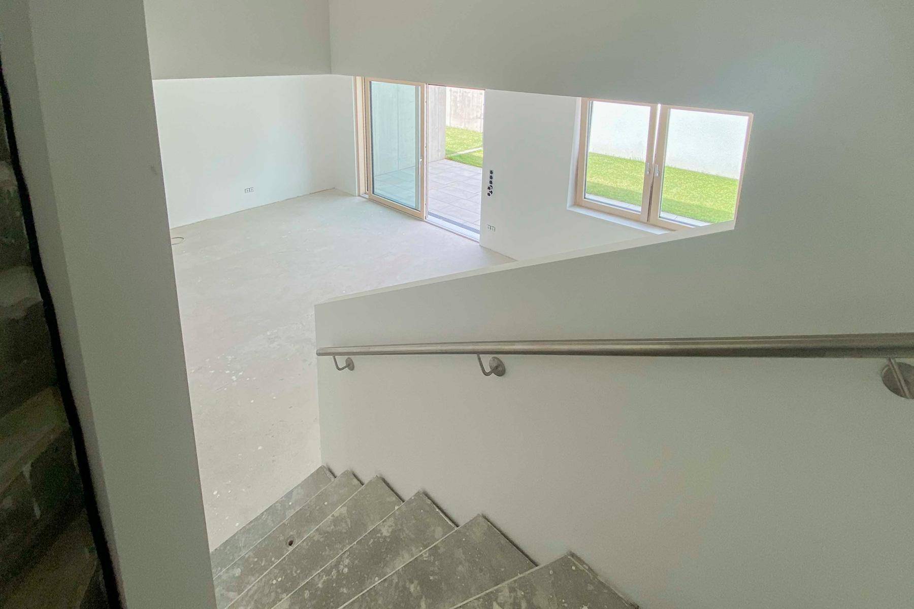 Blick vom Treppenhaus in den unfertigen Wohnbereich mit Terrassenzugang.