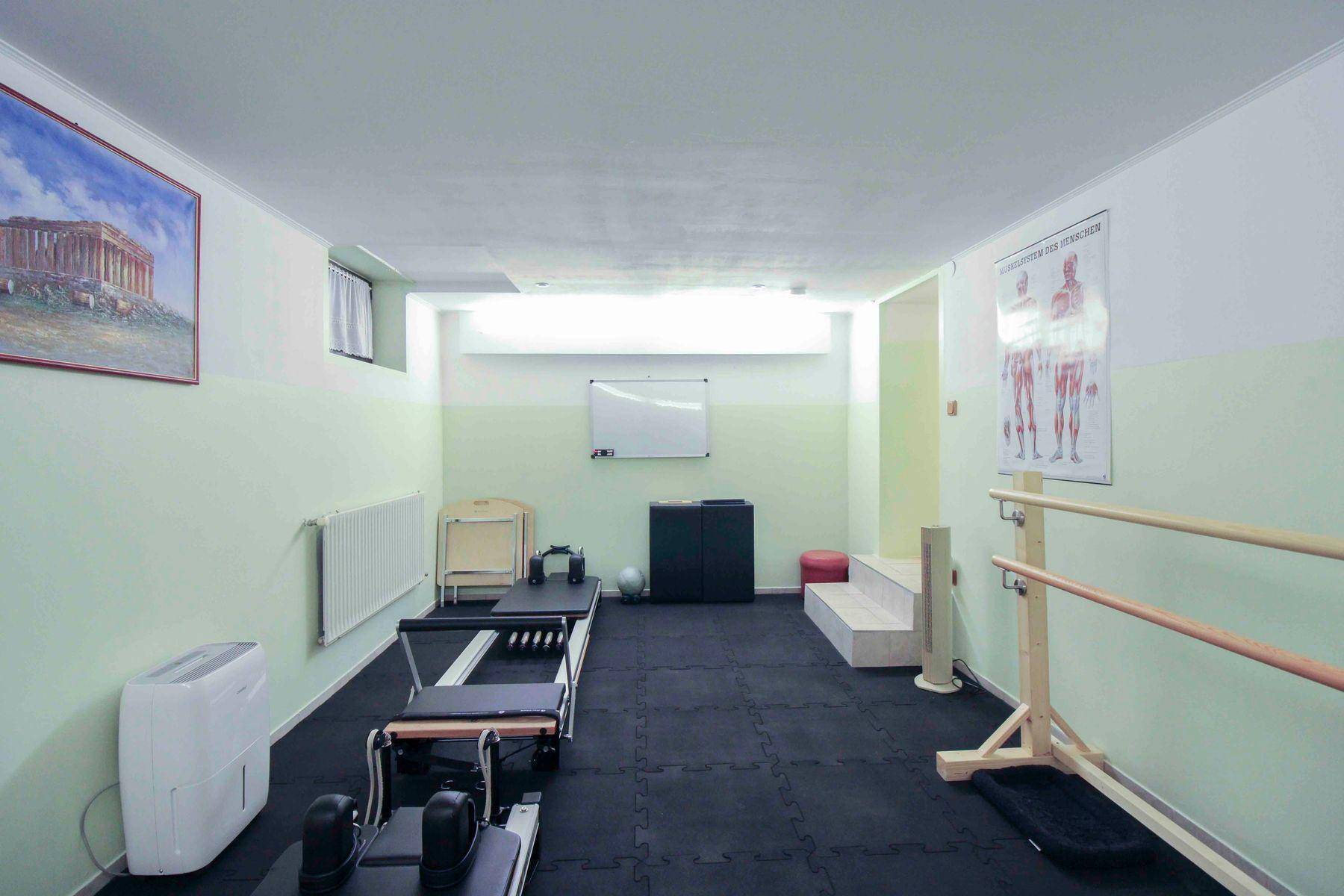 Geräumiger Fitnessbereich im Keller mit verschiedenen Trainingsgeräten und heller Wandgestaltung.