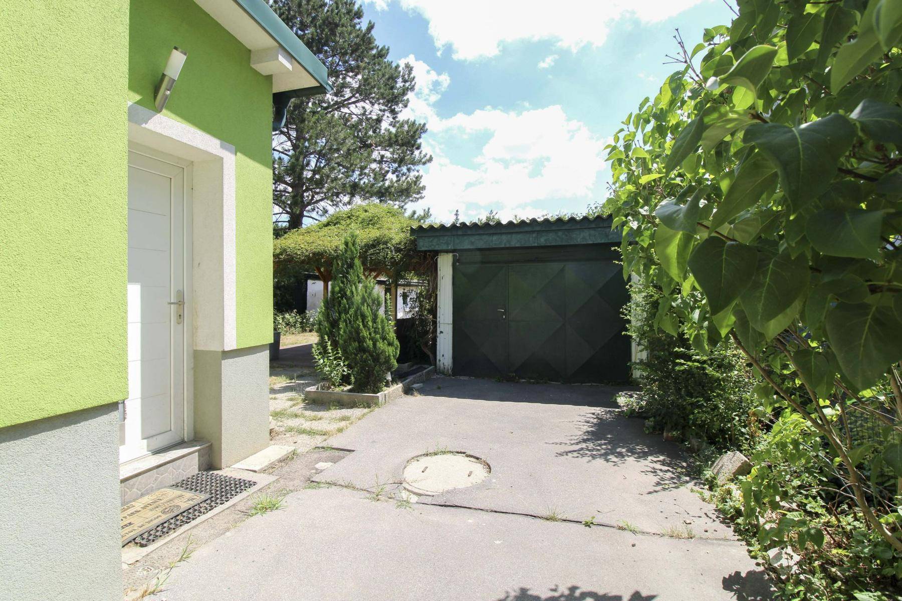 Seitlicher Eingangsbereich des Hauses mit Zufahrt zur Garage.