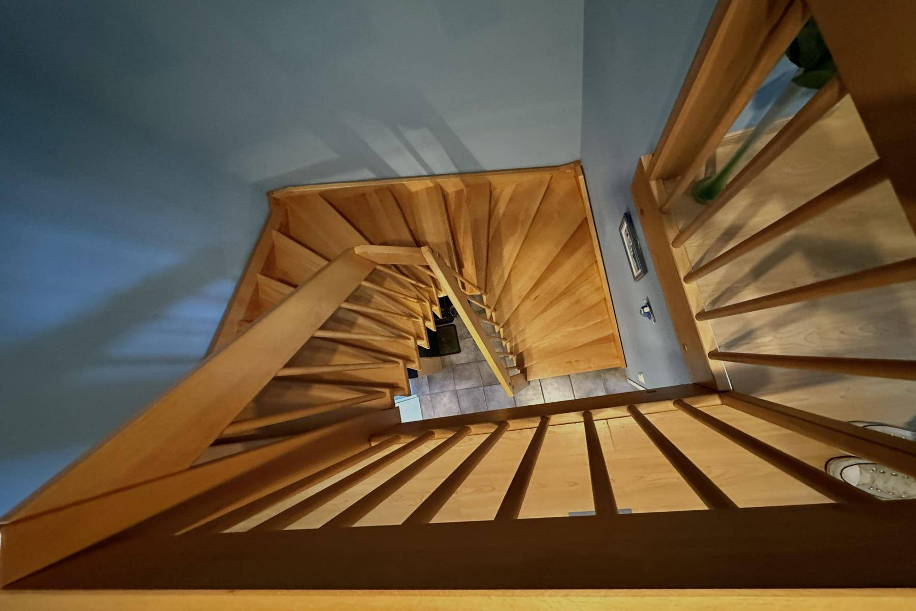 Holztreppe mit mehreren Stufen, die verschiedene Ebenen des Hauses miteinander verbindet.