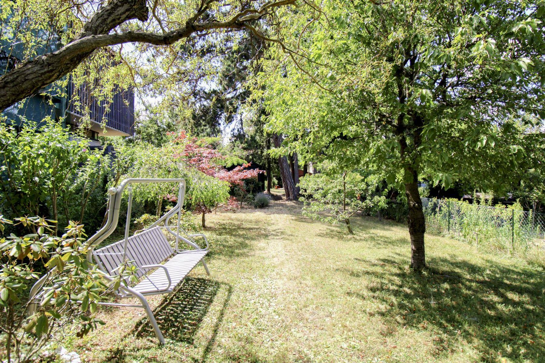 Weitläufiger Garten mit Schaukelbank, Bäumen und viel Grünfläche zum Entspannen.