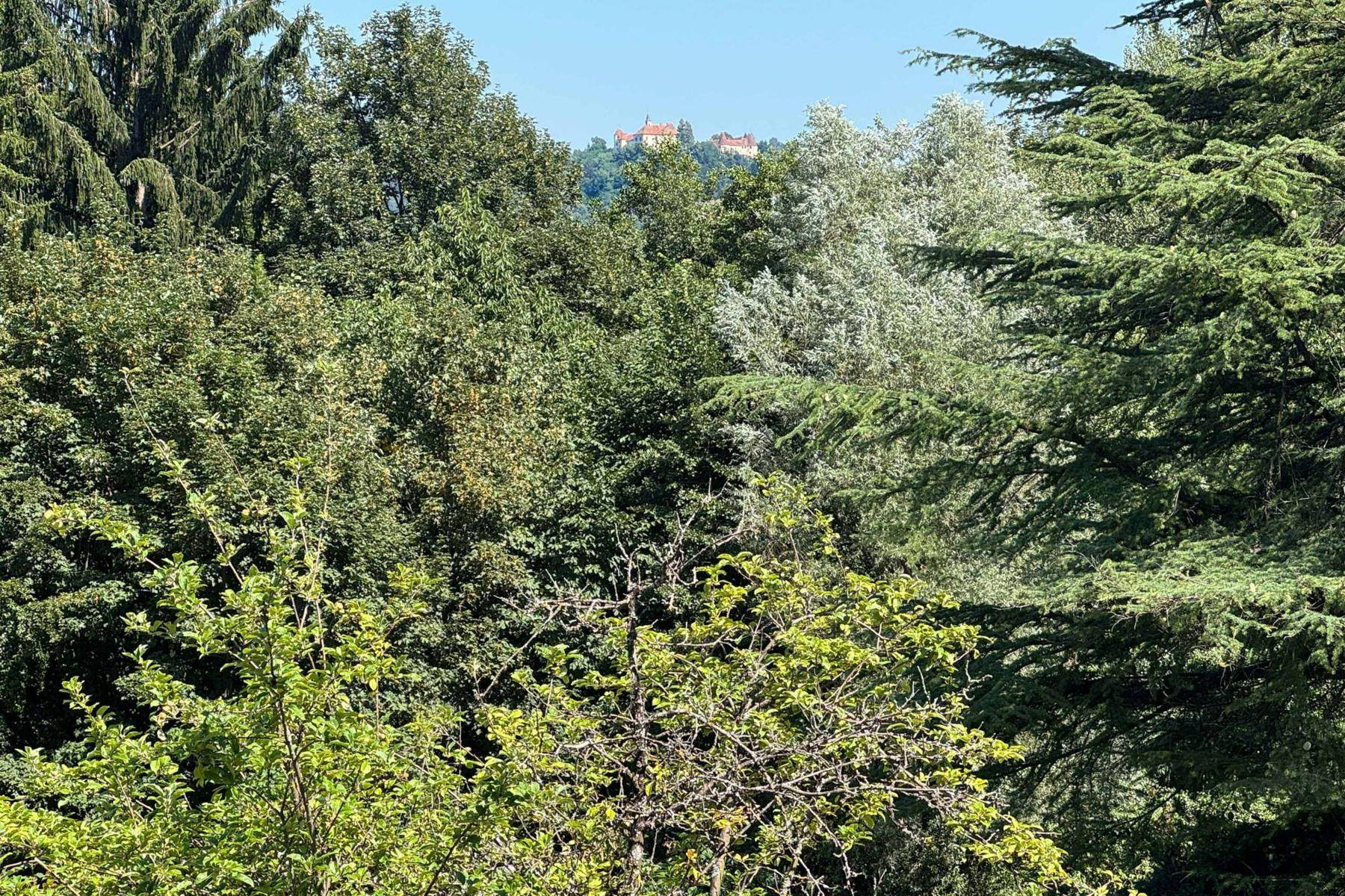 Panoramablick über eine bewaldete Landschaft mit einem historischen Gebäude in der Ferne.
