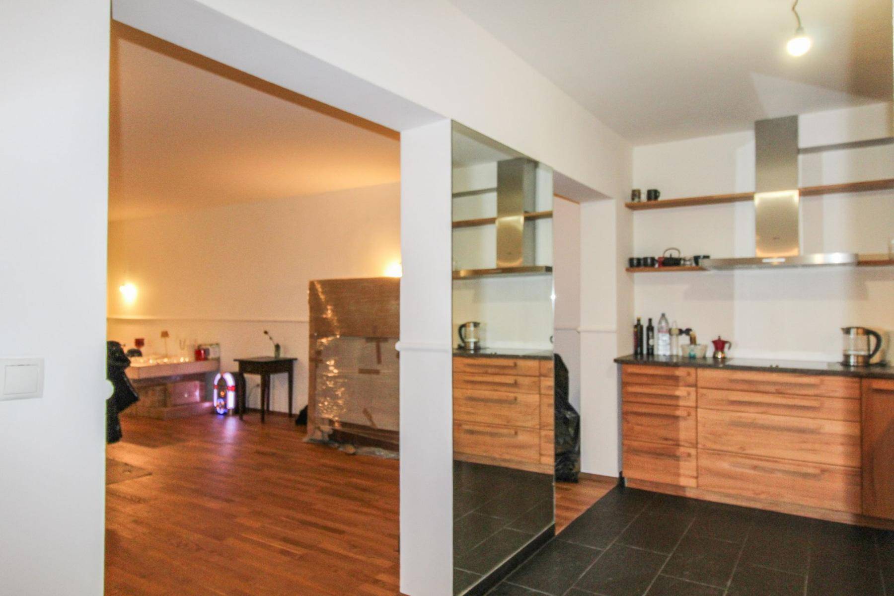 Offener Übergang von der Holzküche zum angrenzenden Wohn- oder Essbereich mit Holzboden.