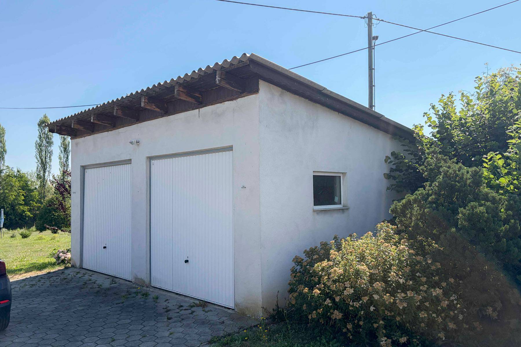 Doppelgarage mit zwei weißen Toren und einem kleinen Fenster.