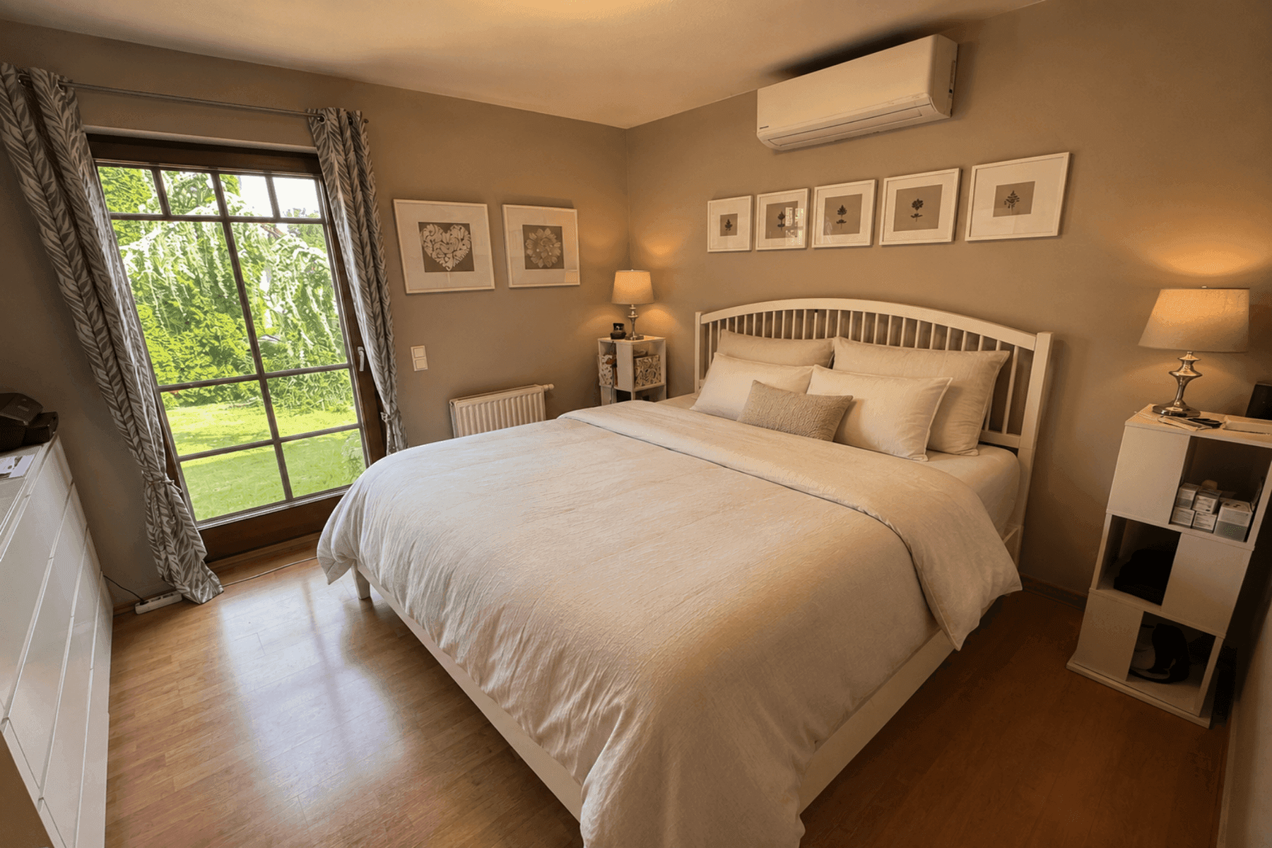Gemütliches Schlafzimmer mit Holzboden, großem Fenster und Klimaanlage.