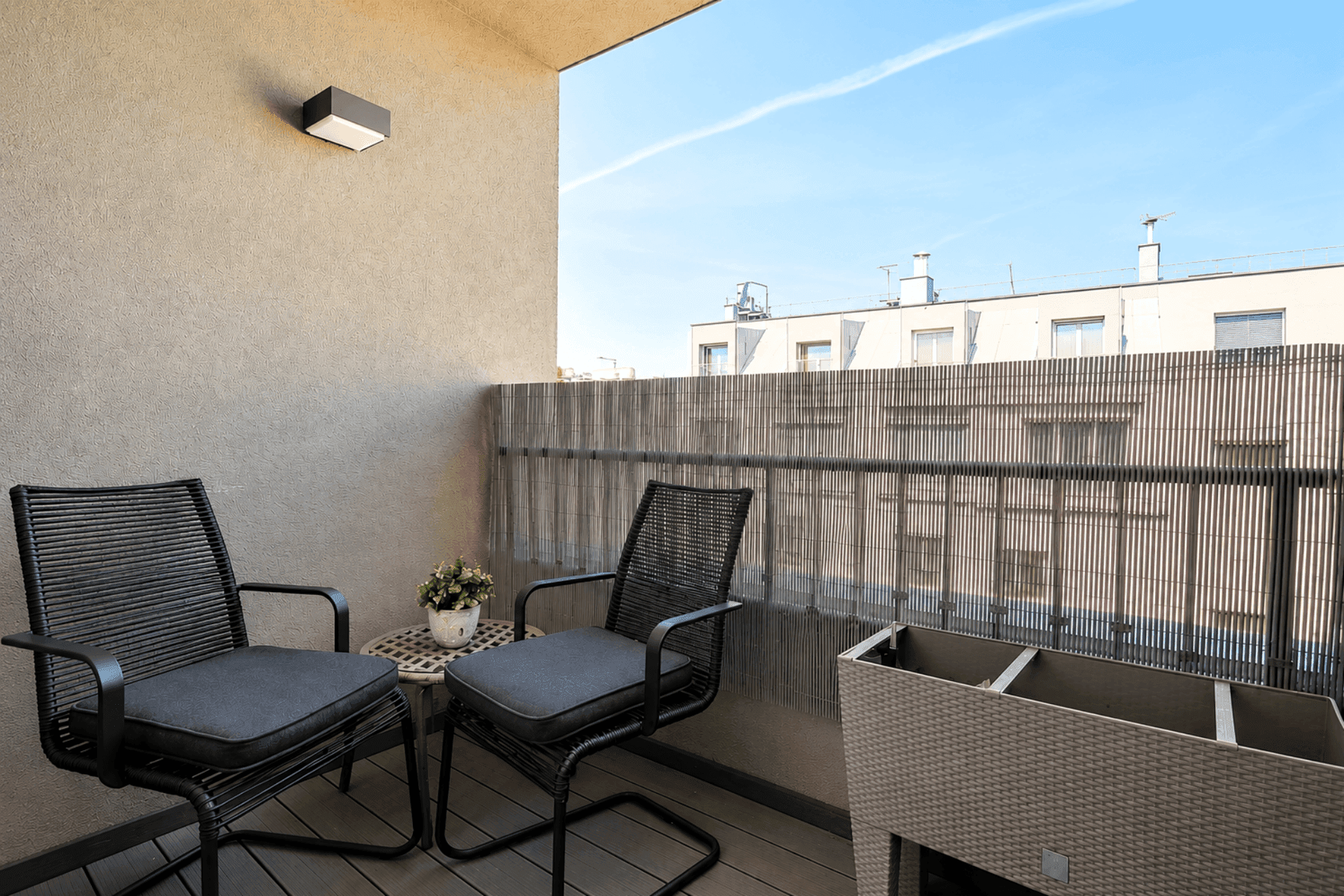Gemütlicher Balkon mit Sitzgelegenheiten und Blick auf die umliegenden Gebäude.