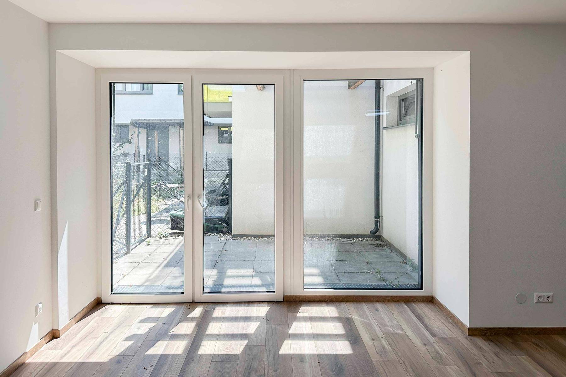 Große Fensterfront im Büroraum bietet viel Tageslicht und Blick auf den Außenbereich.