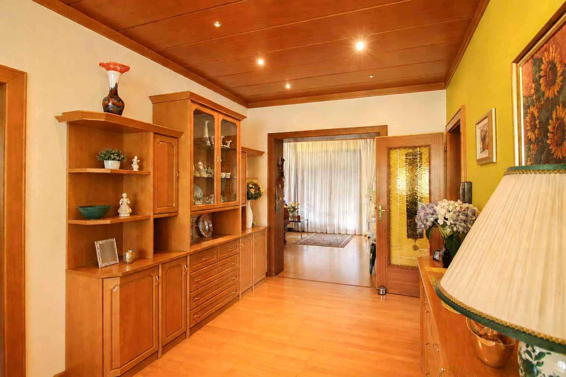 Geräumiger Flur mit Holzdecke, Parkettboden und Vitrinenschrank.